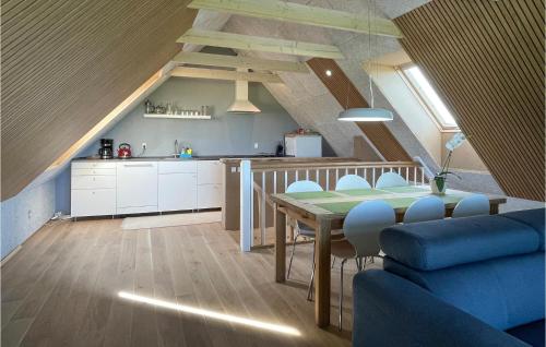 a kitchen and dining room with a table and chairs at Amazing Apartment In Østermarie in Østermarie