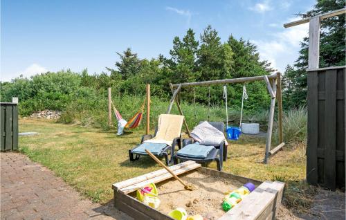 a backyard with two swings and a sandbox at Amazing Home In Hvide Sande With Sauna in Bjerregård