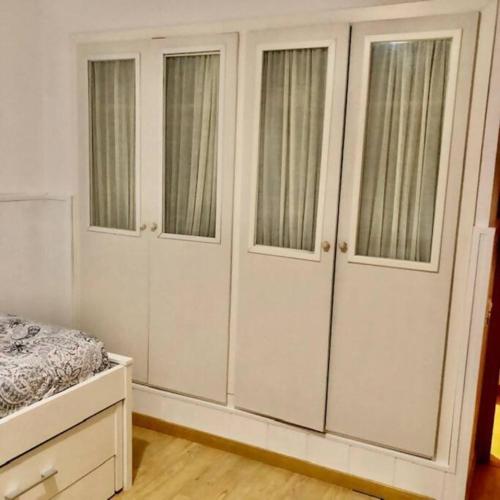 a bedroom with white cabinets and a bed in it at NUEVO Con piscina a 2 minutos estación tren AVE in Zaragoza