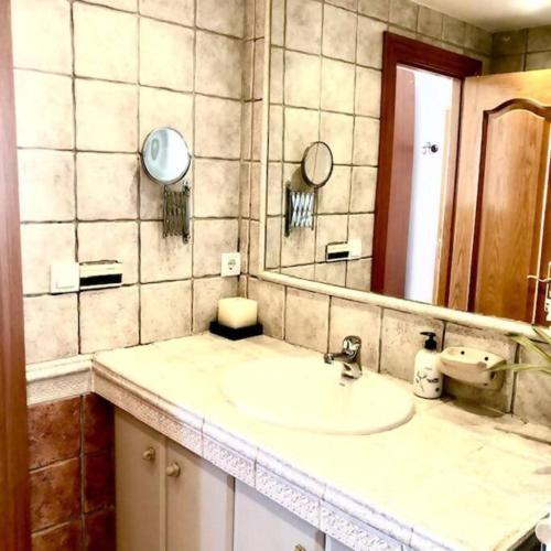 a bathroom with a sink and a mirror at NUEVO Con piscina a 2 minutos estación tren AVE in Zaragoza