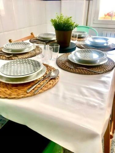 a white table with plates and utensils on it at NUEVO Con piscina a 2 minutos estación tren AVE in Zaragoza