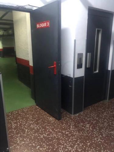 a row of elevators in a building with a red door at NUEVO Con piscina a 2 minutos estación tren AVE in Zaragoza