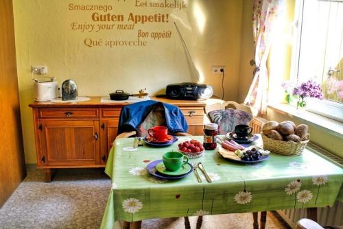 une cuisine avec une table et des assiettes de nourriture dans l'établissement Tolles Ferienhaus in Burhave mit Terrasse und Grill, à Butjadingen