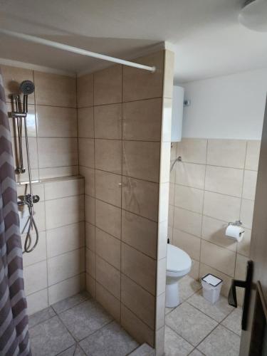 un baño con inodoro y ducha en Melanie apartman 2, en Veľký Meder