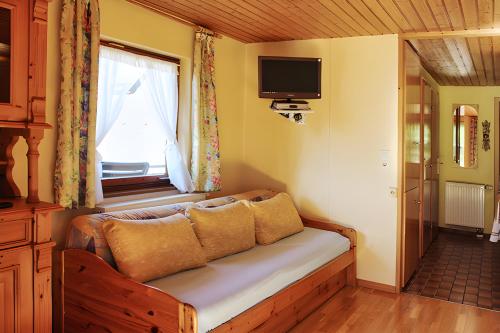 a couch sitting in a room with a window at Small holiday cottage Ivy in Schuttertal