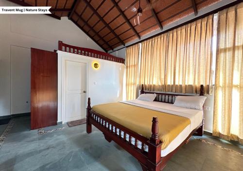 a bedroom with a large bed in a room at Pepper Corn Retreat By Travent Mug in Sakleshpur