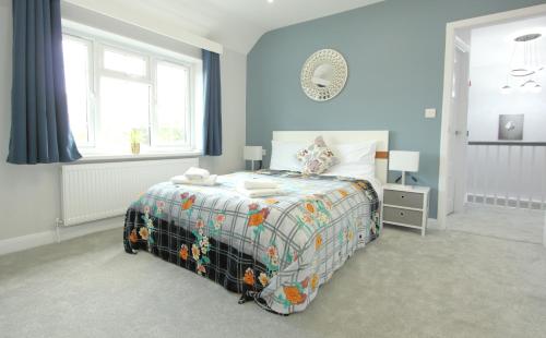 a bedroom with a bed with a colorful comforter at Deluxe 3 Bedroom 2 Bath House &Parking by CozyNest in Reading