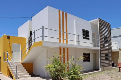 a white house with a staircase on it at Depa cerca Del Consulado 3 in Hermosillo
