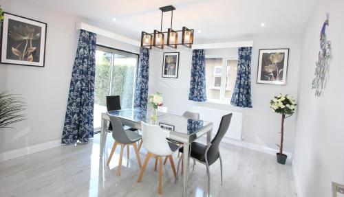 a dining room with a glass table and chairs at Deluxe 3 Bedroom 2 Bath House &Parking by CozyNest in Reading