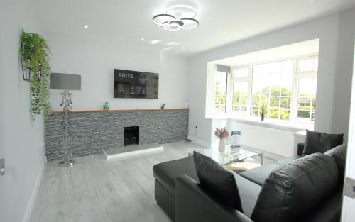 a living room with a couch and a fireplace at Deluxe 3 Bedroom 2 Bath House &Parking by CozyNest in Reading