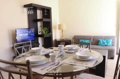 a dining room table with plates and utensils on it at Depa cerca Del Consulado 3 in Hermosillo