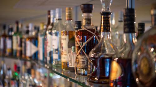 a row of bottles of alcohol on a bar at Hotel Badhof in Altstätten