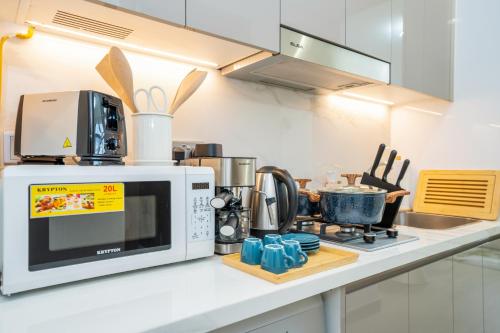 a microwave oven sitting on a counter in a kitchen at Zapbed House - Modern Studio in Azizi Riviera 27 Meydan One in Dubai