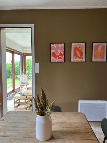 d'une salle à manger avec une table et une plante. dans l'établissement Oyat, à Saint-Hilaire-de-Riez