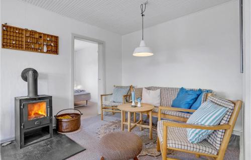 un soggiorno con stufa a legna e tavolo di Holiday Home Tranebærvej Oksbøl Iii a Vejers Strand