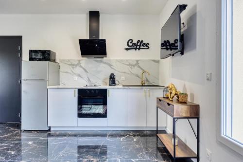 a kitchen with white appliances and a table in it at Studio 1 in Coubron