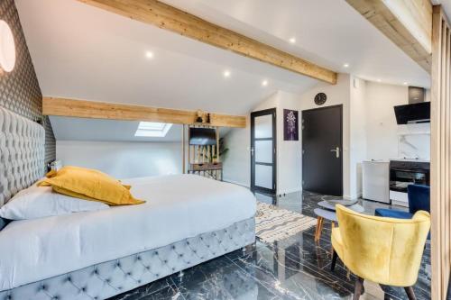 a bedroom with a large white bed and yellow pillows at Studio 1 in Coubron