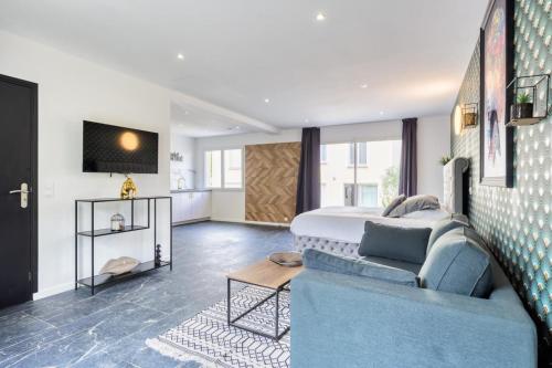 a bedroom with a bed and a blue couch at Studio 1 in Coubron