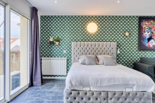 a bedroom with a large bed and a green wall at Studio 1 in Coubron