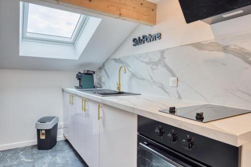 a kitchen with white cabinets and a counter top at Studio 1 in Coubron