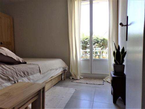 une chambre avec un lit et une porte avec une fenêtre dans l'établissement Appartement avec jardinet et terrasse, à Saint-Jean-de-Luz
