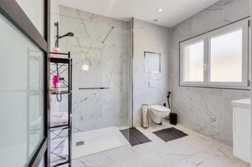 a white bathroom with a shower and a toilet at Studio 1 in Coubron