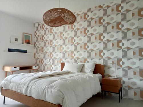 een slaapkamer met een groot bed en een muur bedekt met behang bij La villa des vignes in Castillon-du-Gard