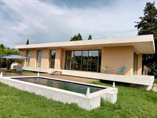 een huis met een zwembad ervoor bij La villa des vignes in Castillon-du-Gard