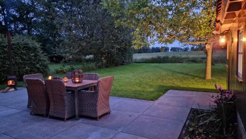 a table with wicker chairs sitting on a patio at Huisje Weidezicht in Lievelde