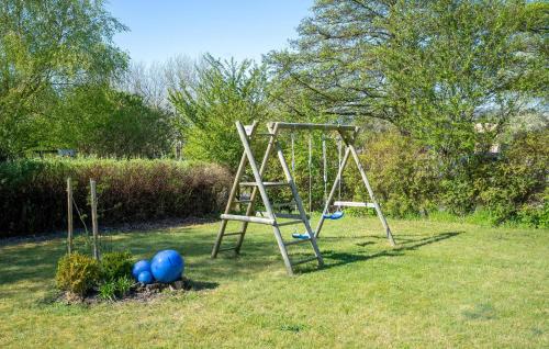 a swing set in a yard with blue balls at Nice Home In Skælskør With Sauna in Skælskør