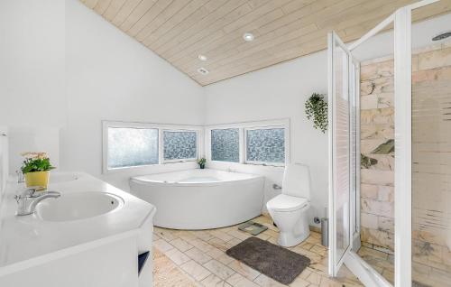 a white bathroom with a tub and a toilet at Nice Home In Skælskør With Sauna in Skælskør