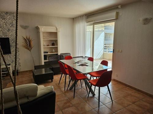 une salle à manger avec une table et des chaises rouges dans l'établissement Appartement génial en centre ville avec parking, à Cavalaire-sur-Mer