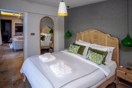 a large white bed in a room with a mirror at Kaya Villas Exclusive in Kayakoy