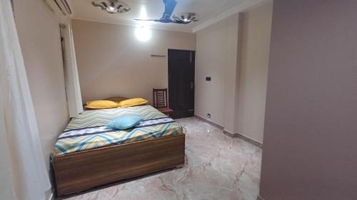 a small bedroom with a bed in a room at SHI's Thulasi 2BHK in Coimbatore Near to Karpagam College, Palakkad Highway, Rathinam College and More in Coimbatore