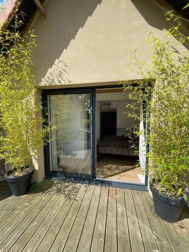 une porte coulissante en verre sur une terrasse avec des plantes dans l'établissement ROSITA, à Noyelles-sur-Mer