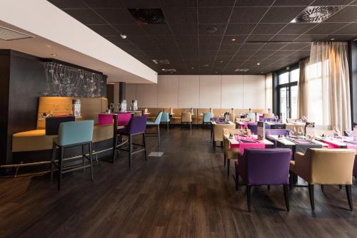un comedor con sillas y mesas moradas en Mercure Cherbourg Centre Port, en Cherbourg-en-Cotentin