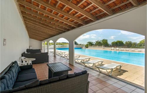 a swimming pool with a couch and chairs next to a swimming pool at Stunning Home In Tranekær in Tranekær