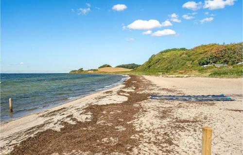 a beach with two umbrellas sitting on the sand at Stunning Home In Tranekær in Tranekær