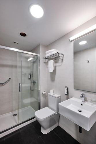 a bathroom with a toilet and a shower and a sink at Hotel Lux Santiago in Santiago de Compostela