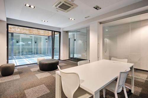 a meeting room with a white table and chairs at Hotel Lux Santiago in Santiago de Compostela