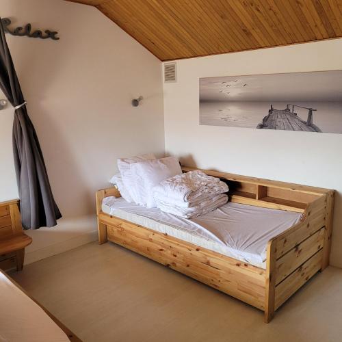 - une chambre dotée d'un lit en bois avec une photo sur le mur dans l'établissement Maison Fouras centre 3 étoiles, à Fouras