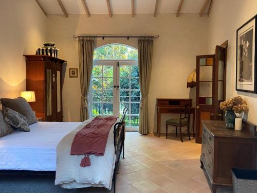 a bedroom with a bed and a desk and a window at Guestlands Italia B&B in Arcadia