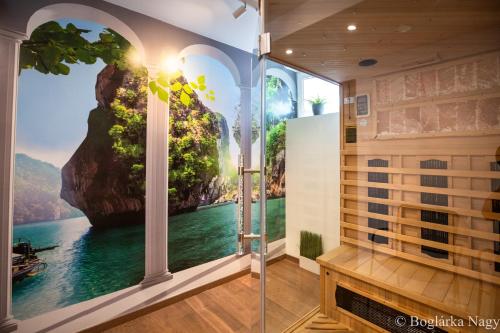 a bathroom with a shower with a painting on the wall at Love and Dream Élményvilla in Zalakaros