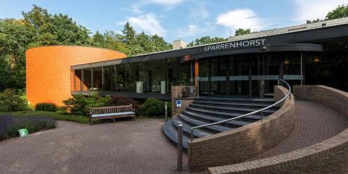 a building with a bench in front of it at Fletcher Hotel-Restaurant Sparrenhorst-Veluwe in Nunspeet