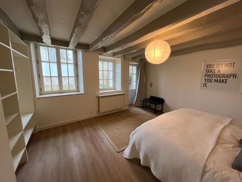 a bedroom with a large bed and a lamp at Le presbytère 30 min de Beauval in Les Montils