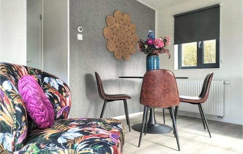 a living room with a couch and a table with a vase of flowers at 2 Bedroom Cozy Home In Heinkenszand in Heinkensand