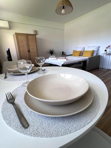 - une table blanche avec des assiettes et des verres à vin dans l'établissement Mandelieu proche des plages, à Mandelieu-la-Napoule