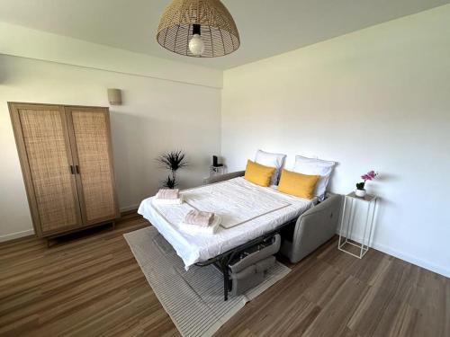 une chambre avec un lit avec des oreillers jaunes dessus dans l'établissement Mandelieu proche des plages, à Mandelieu-la-Napoule