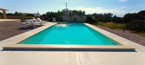 une piscine avec un banc à côté dans l'établissement Trullomio, à Torre Suda