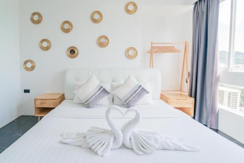 two white swans forming a heart on a bed at Patong Diamond Hotel in Patong Beach